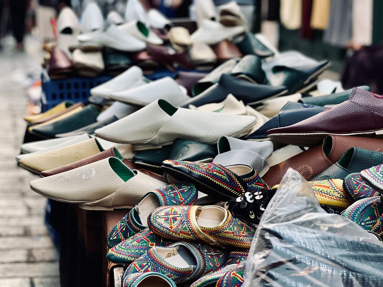 A vibrant selection of Moroccan slippers displayed at an outdoor market stall.