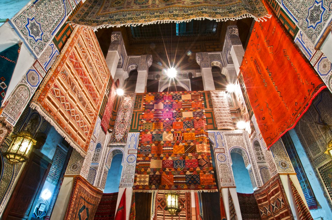 portfolio-05 Colorful traditional Moroccan rugs hung inside historical architecture in Fès, Morocco.