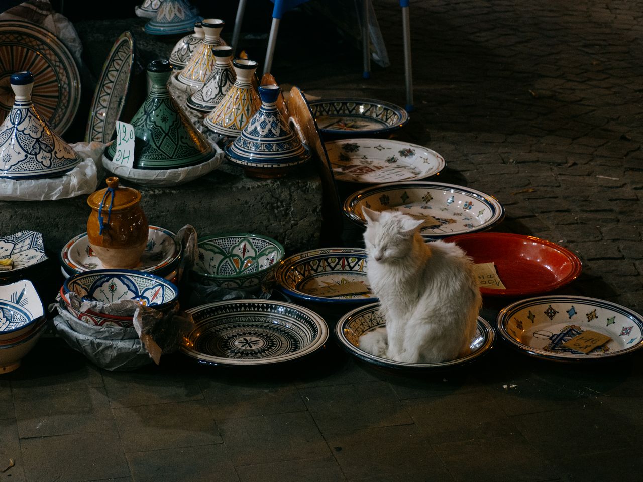 Beautiful Moroccan ceramics with a cat in a night market setting.