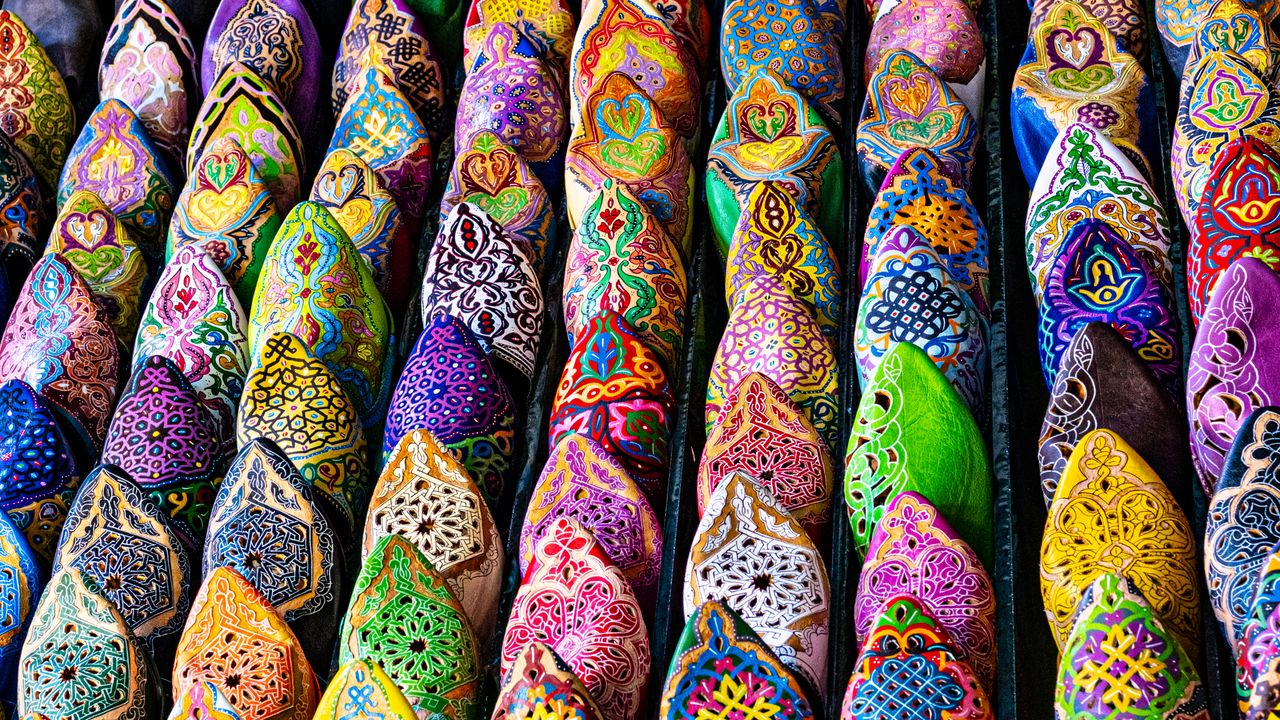 portfolio-04 Vibrant handcrafted Moroccan slippers on display in Marrakesh, showcasing traditional artistry.