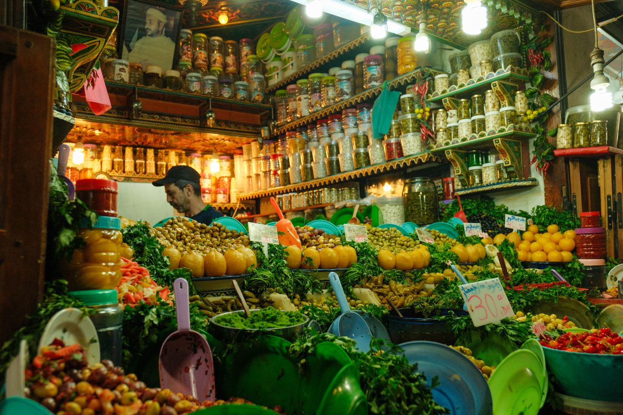 portfolio-01 Colorful array of spices and produce in a bustling market stall in Fes, Morocco.